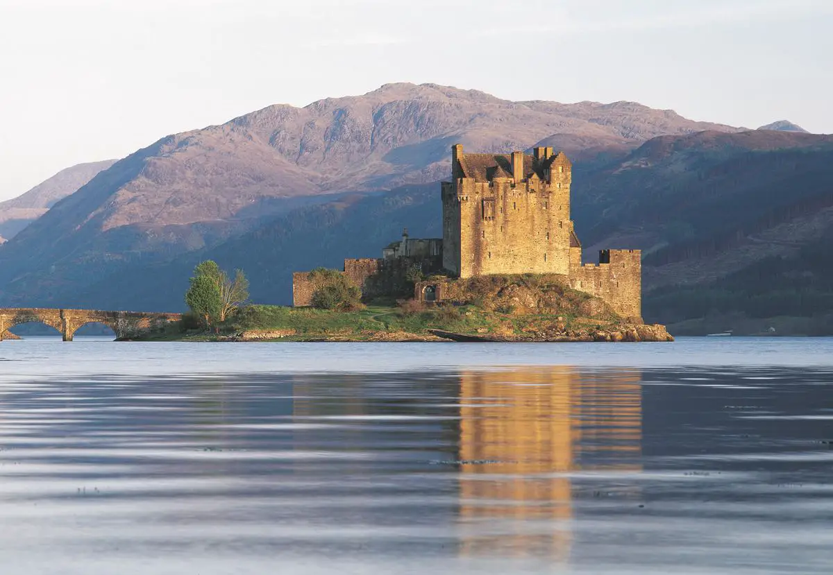 Eine alte Festung auf einem Hügel mit einer Flagge darauf. Es ist ein wichtiges Symbol für Schottland, da es die bedeutende Geschichte und die Identität des Landes repräsentiert.