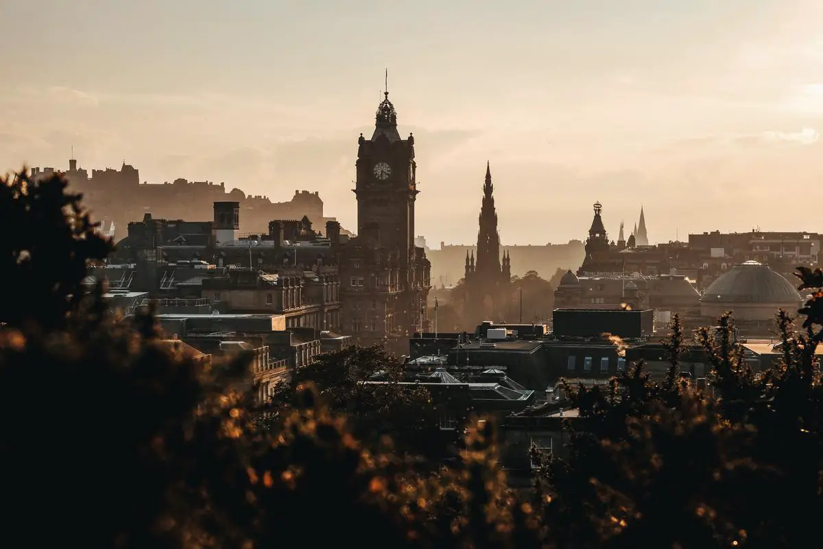Ein Bild von der Stadt Edinburgh mit einem klaren Himmel und vielen grünen Bäumen am Straßenrand, um das Engagement von Edinburgh bei der Bekämpfung des Klimawandels zu symbolisieren.