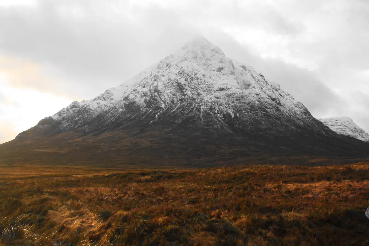 Ein Bild von Schottland im Winter mit einer verschneiten Landschaft, Bergen und Wintersportarten.